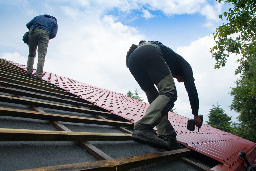 Two roofers installing a new roof on a home