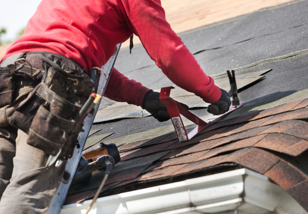 Roofer on a ladder making an emergency roof repair